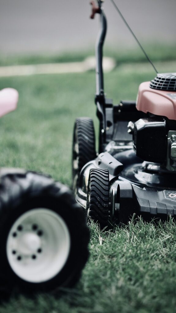 A push mower with large rear wheels on a freshly cut green lawn